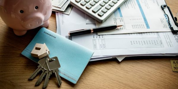 Documentos junto a llaves de casa y alcancía